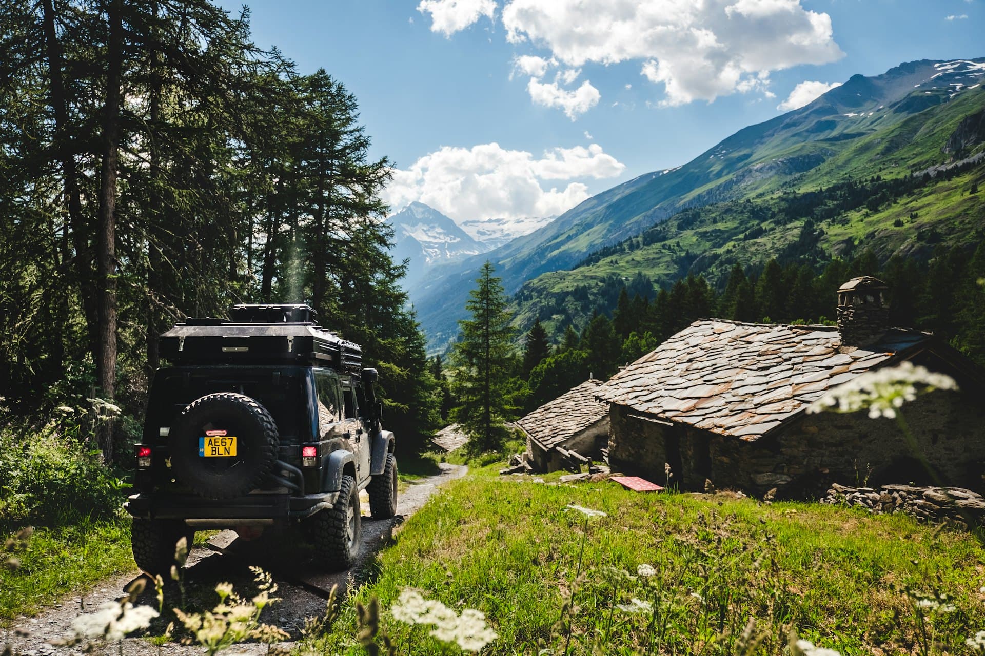 A car on a green mountain road in the Caucasus